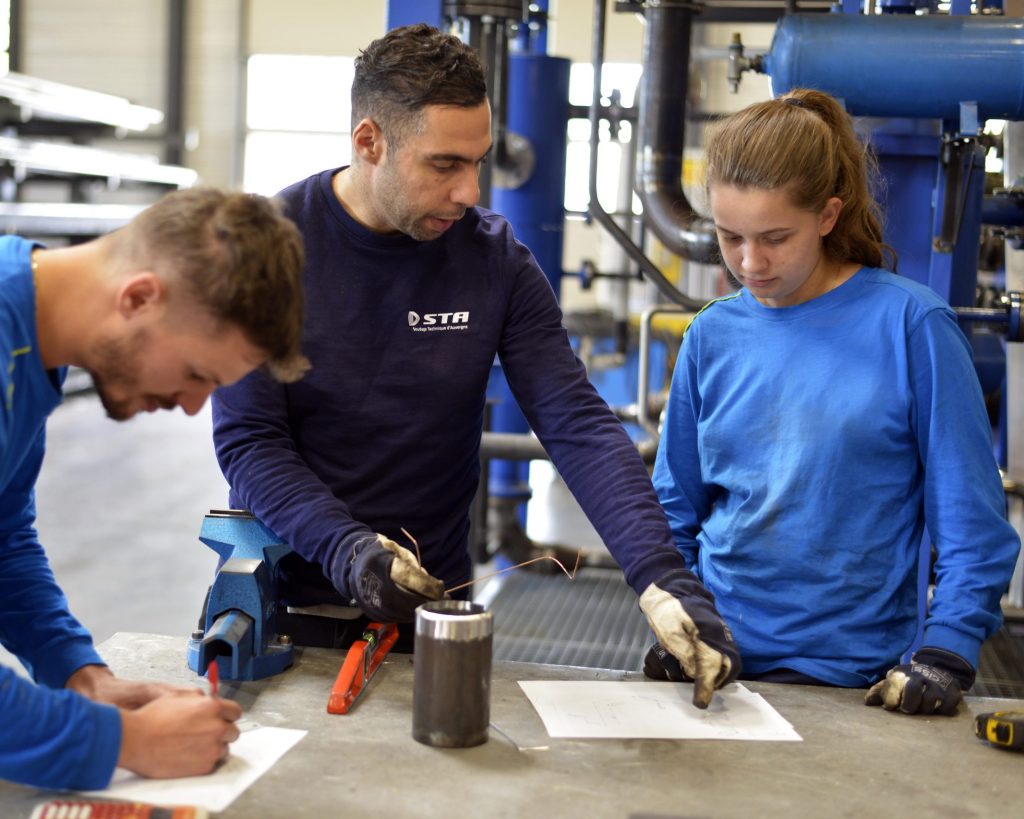 Deux stagiaires en formation CQPM Tuyauteur accompagné d'un formateur pour de la lecture de plan