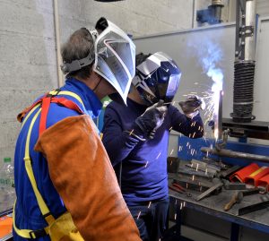 Un apprenti en soudure accompagné de son formateur