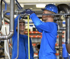 deux stagiaires en formation CQPM Tuyauteur en train de travailler sur SKID